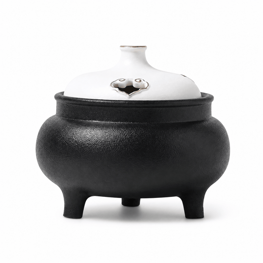 Classic black and white ceramic electric incense burner with a lidded three-leg design for flameless incense heating and home fragrance.