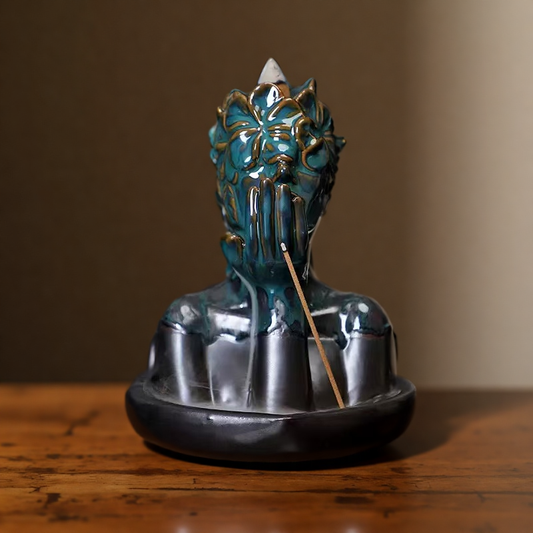 Front view of floral mask backflow incense burner with incense cone and stick