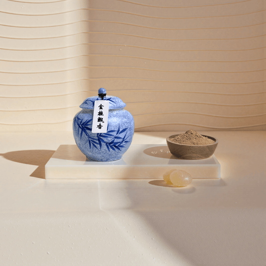 Golden Osmanthus handcrafted natural incense powder in a blue ceramic jar, with some placed in a wooden bowl to show the powder.