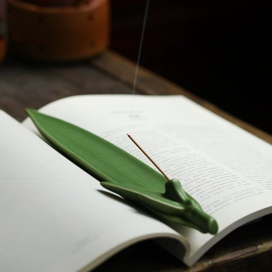 Green leaf ceramic incense holder on book