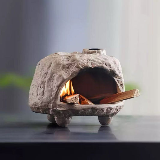 Front view of handmade ceramic incense burner with textured finish, burning palo santo stick inside with visible warm glow for meditation and purification rituals