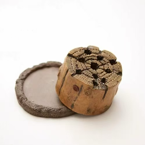 Wood-stump shaped incense burner with circular base mat on white background