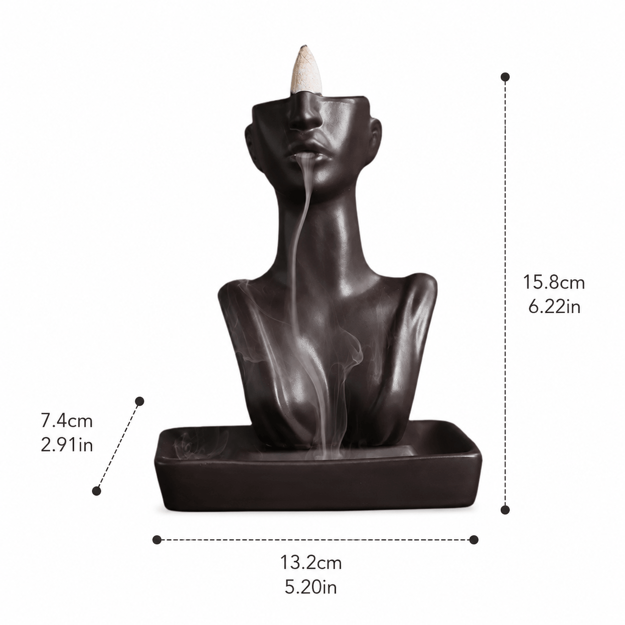 Abstract face ceramic backflow incense burner with smoke flowing from the lips, shown with size measurements of 15.8 cm high, 13.2 cm wide, and 7.4 cm deep.