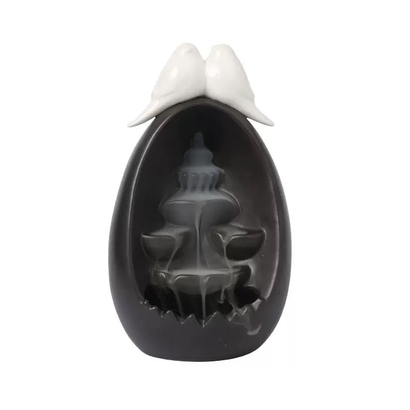 Front view of the Backflow Incense Burner Ceramic Waterfall with Doves, featuring a black ceramic waterfall design with two dove figures on top and tiered backflow channels for cascading incense smoke