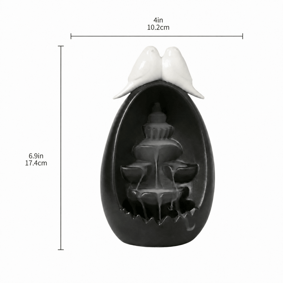 Ceramic backflow incense burner in a black oval waterfall design with two white doves on top, shown with size markings of 4 in / 10.2 cm width and 6.9 in / 17.4 cm height.