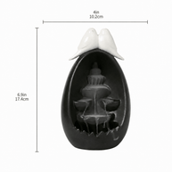 Ceramic backflow incense burner in a black oval waterfall design with two white doves on top, shown with size markings of 4 in / 10.2 cm width and 6.9 in / 17.4 cm height.