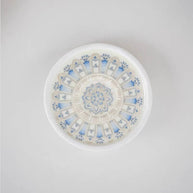 Bottom view of a round blue and white ceramic lotus incense holder showing the decorative floral pattern on the base