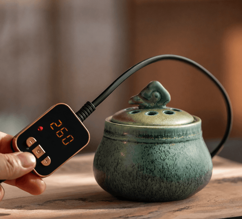 Ceramic electric incense burner with handheld temperature controller for flameless aroma heating, adjustable heat control, and everyday home fragrance use.