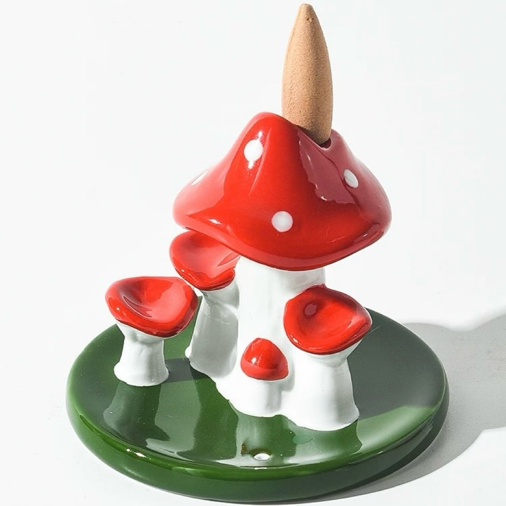 Red and white ceramic mushroom backflow burner with a brown incense cone placed on the top cap opening