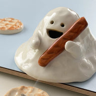Hand-painted ceramic ghost incense holder for cone incense, glossy white with matching bases in a lifestyle scene.