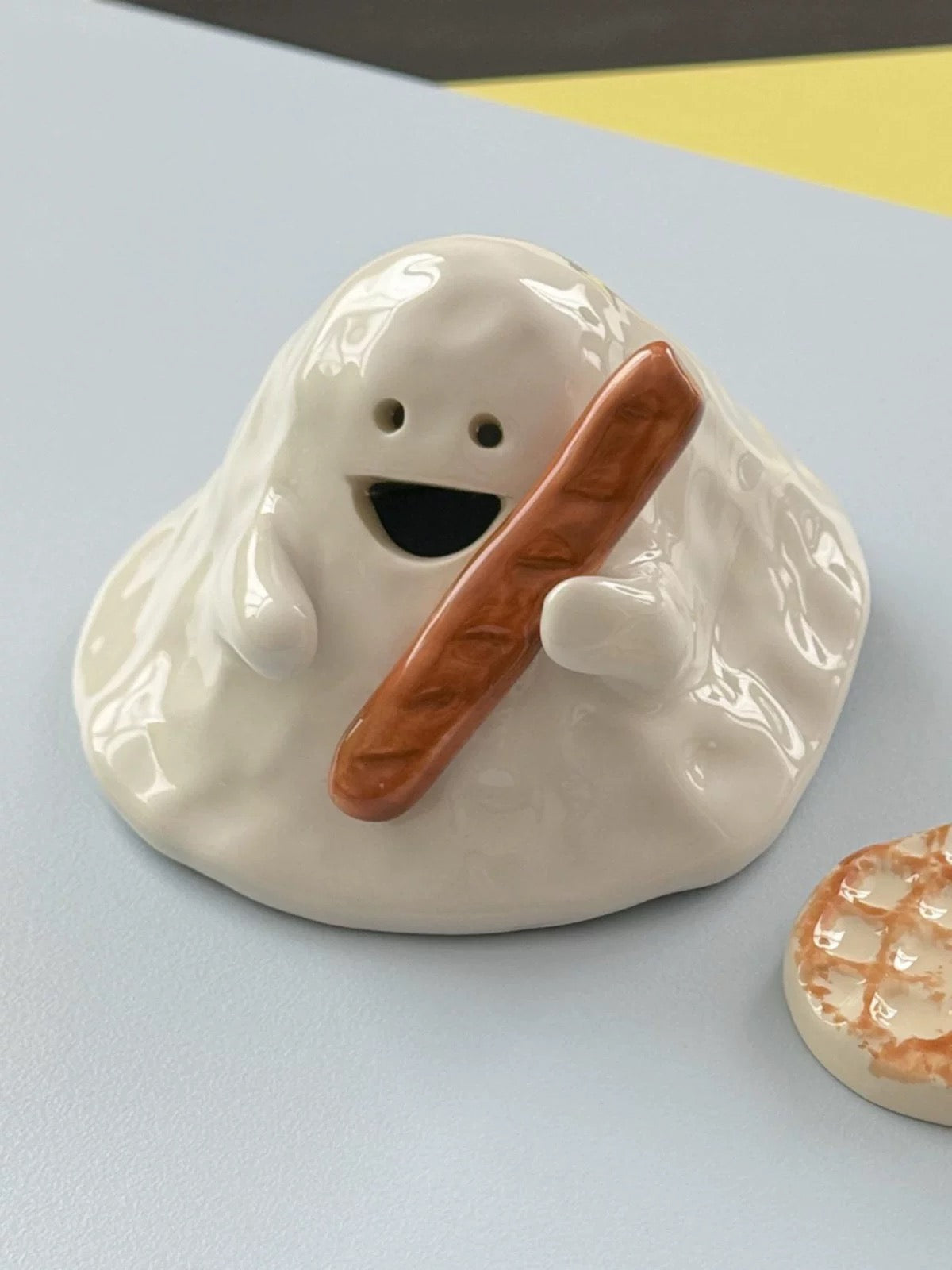 Hand-painted ceramic ghost incense holder for cone incense, glossy white with matching base, top view on a light background.