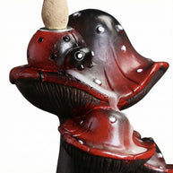Close-up of a creative resin mushroom backflow incense burner featuring red and black mushroom caps with white spots, designed to let incense smoke cascade downward like a misty waterfall.