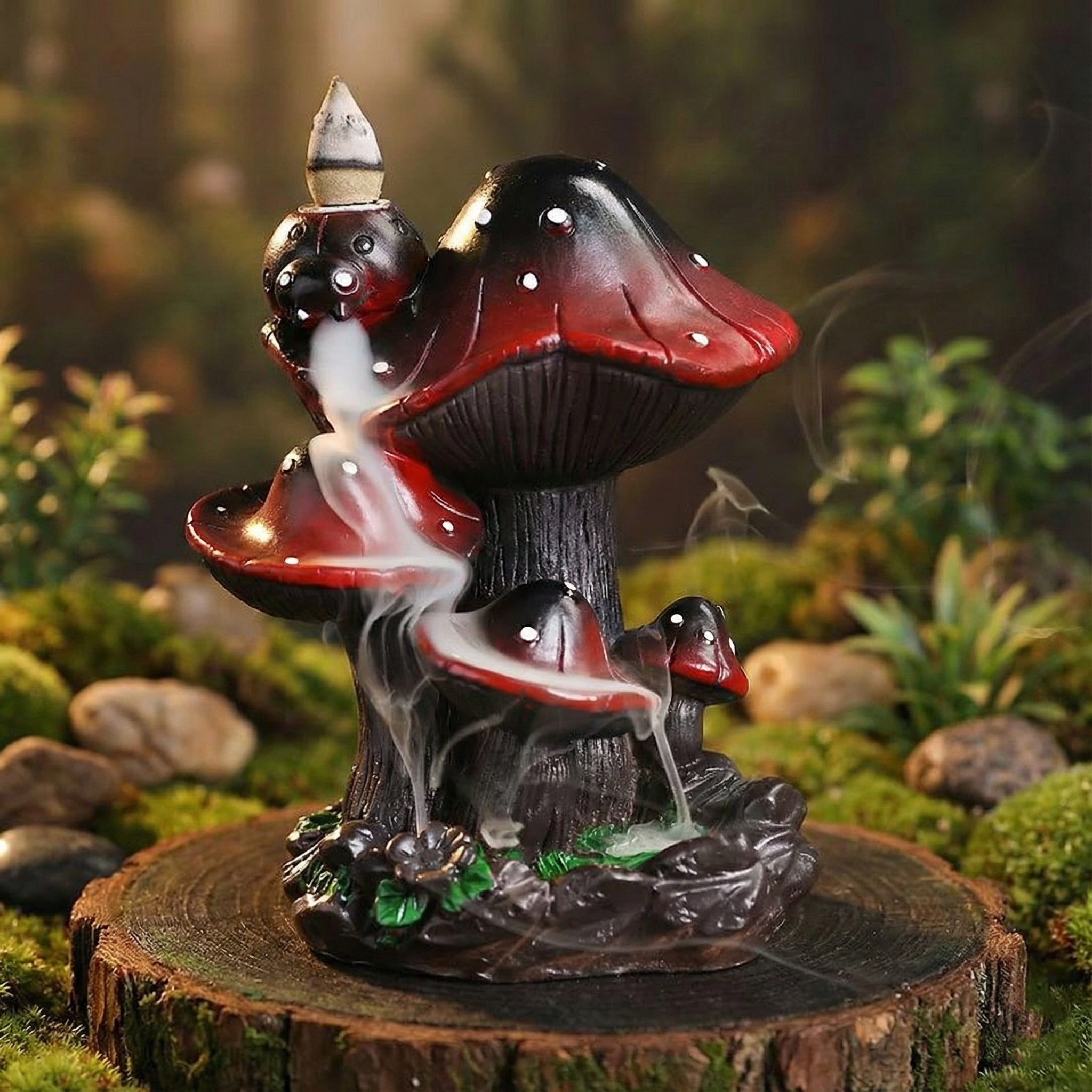 Creative resin mushroom backflow incense burner featuring a cluster of red and black mushrooms with smoke cascading downwards like a misty waterfall on a wooden base with a mossy background.