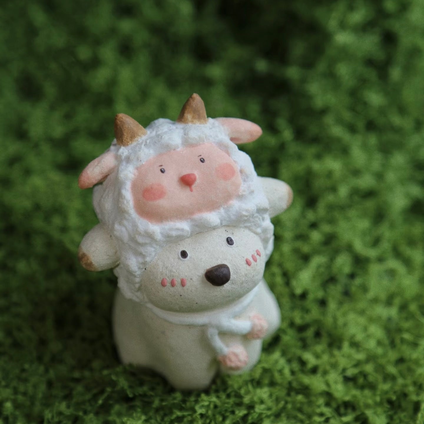 Custom handmade ceramic incense holder featuring a cute bear in a sheep costume, displayed at an angle on green moss with a soft natural background