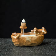 Full side view of a cute brown animal bathtub backflow incense burner with an incense cone holder and smoke channel inside the tub