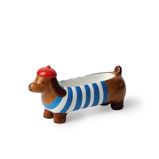Brown ceramic dachshund incense holder with blue-white stripes and a red beret, three-quarter view on a white background.
