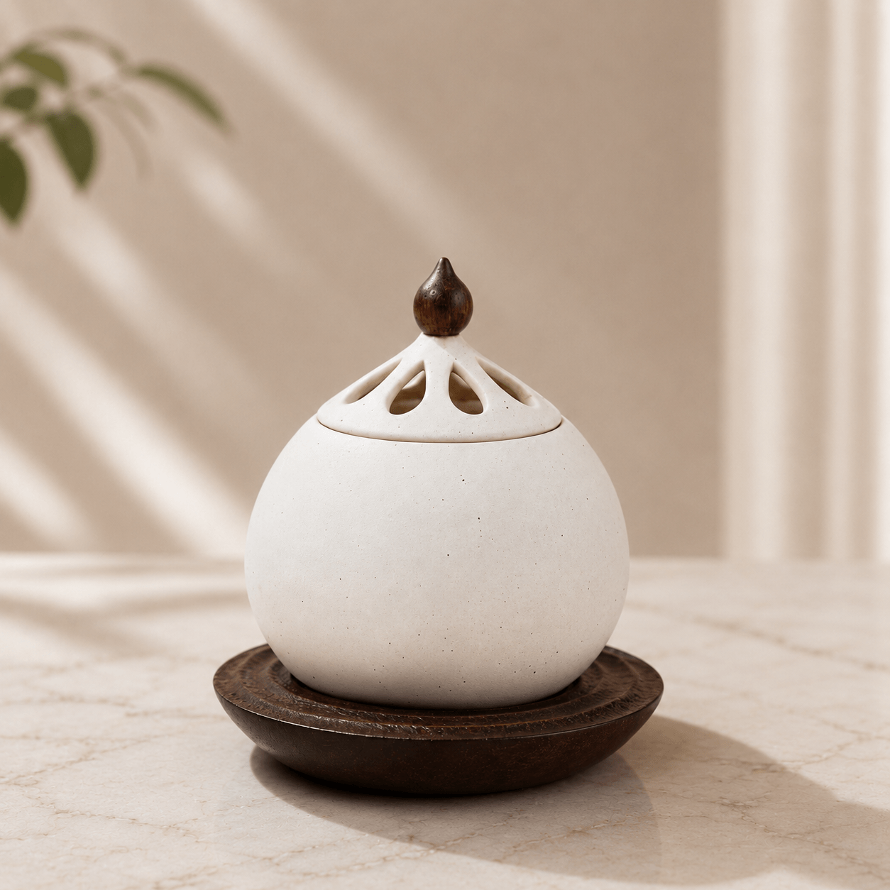 A close-up of a white electric ceramic incense burner resting on a solid wood base, sitting on a light-colored table in soft sunlight.