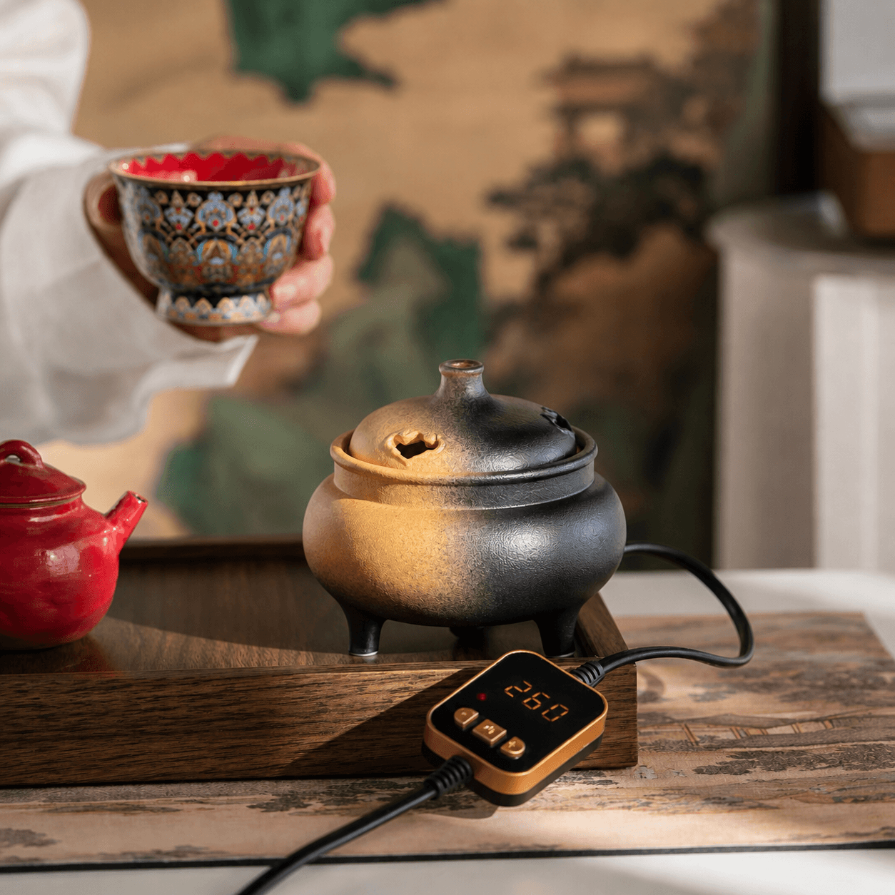 Ceramic electric incense burner with temperature controller on a tea table, creating a flameless home fragrance experience for tea rooms, meditation, and relaxation spaces.