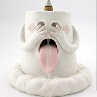 Handcrafted backflow incense burner smoke waterfall holder shaped like a blushing ghost with hands over its eyes, tongue out, and an incense cone on top against a white background