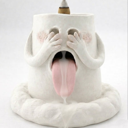 Handcrafted backflow incense burner smoke waterfall holder shaped like a blushing ghost with hands over its eyes, tongue out, and an incense cone on top against a white background