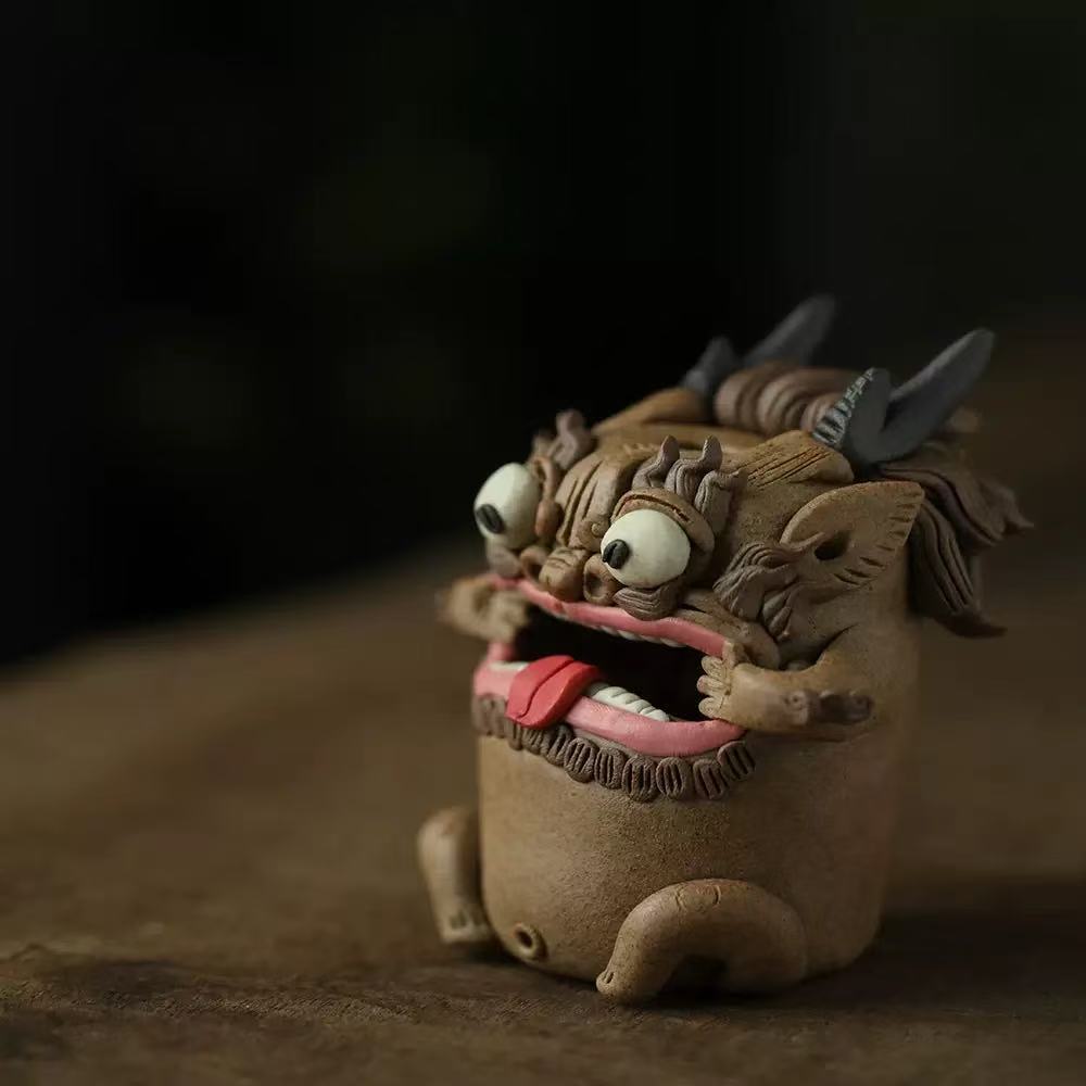 High‑angle view of a handcrafted purple clay guardian backflow incense burner on a wooden table, showing its detailed sculpted horns, bulging eyes, expressive open mouth, and cascading white mist.