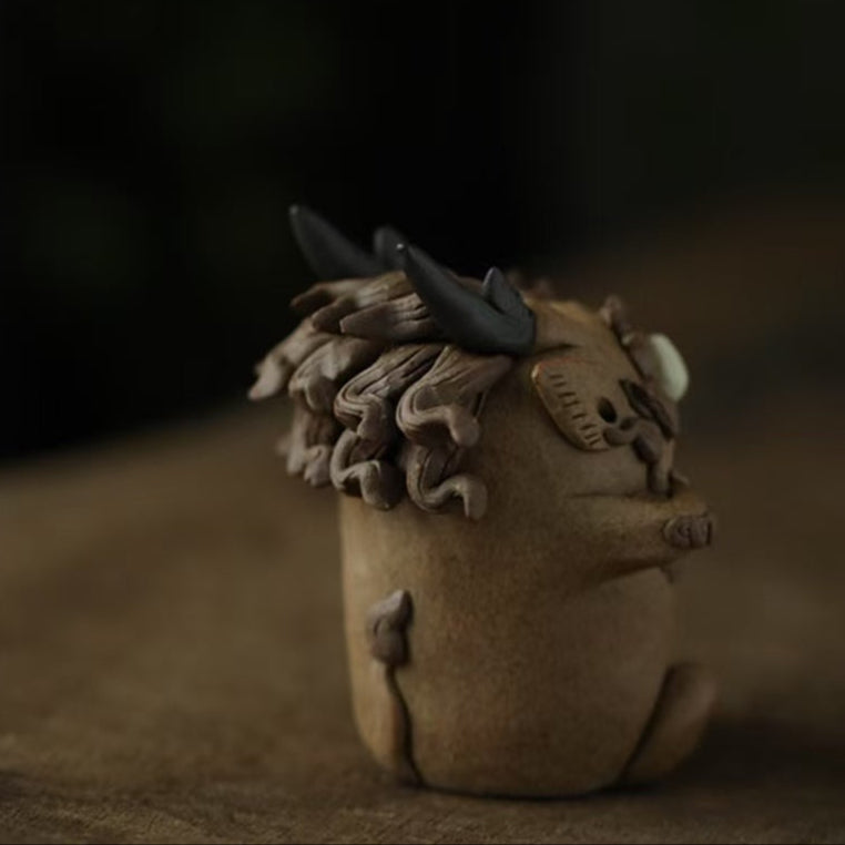 Side‑rear view of a handcrafted purple clay guardian backflow incense burner on a wooden surface, showcasing its sculpted horns, curled clay mane, and textured back profile with faint incense mist in the background.