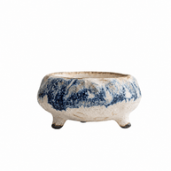 Handmade cream ceramic incense holder with blue marbled glaze and three short feet displayed on a white background