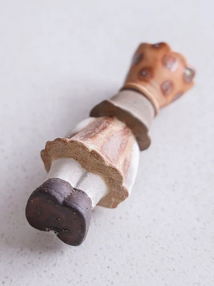 Ceramic girl incense burner lying on its back showing the underside and crown top details on a light surface.