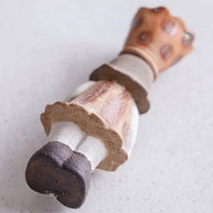 Ceramic girl incense burner lying on its back showing the underside and crown top details on a light surface.