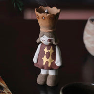 Handcrafted ceramic girl figurine incense burner with a crown-shaped top for cone incense, star-patterned dress, standing on a dark background.