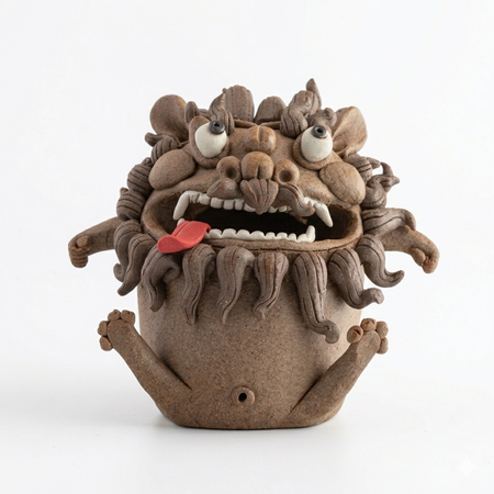 Handmade ceramic guardian beast backflow incense burner with bulging eyes, curled mane, fangs, and tongue out on a white background