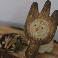 Angled lifestyle view of The Hungry Foodie Cat handmade ceramic incense holder on a rustic wood surface with a matching ash tray in the background
