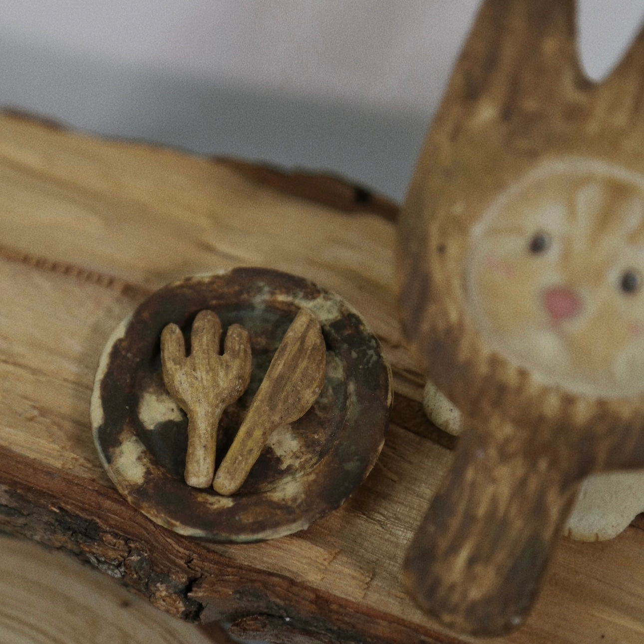 Close-up of the matching ash tray with fork and knife details from The Hungry Foodie Cat handmade ceramic incense holder set on a rustic wood surface