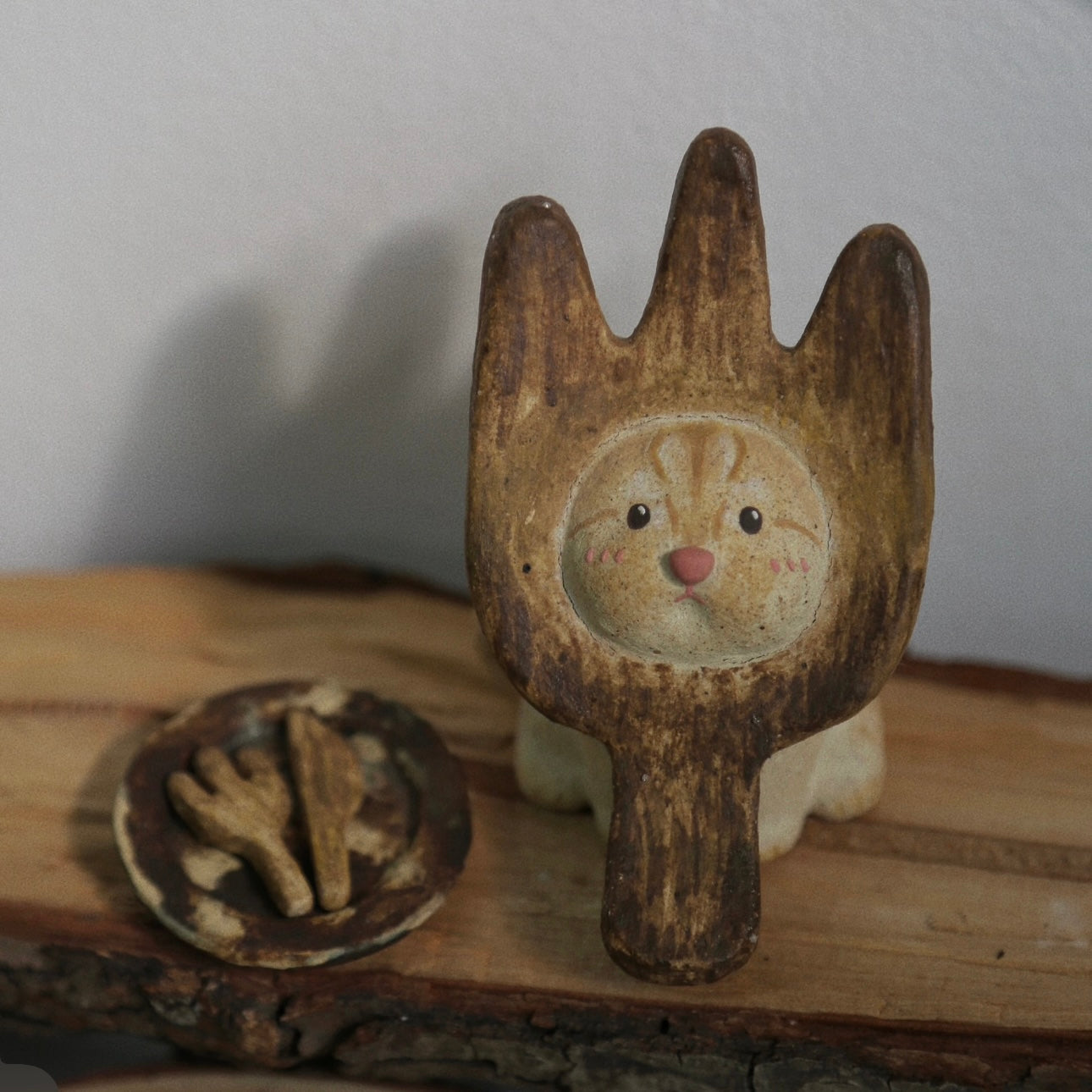 Handmade ceramic incense holder shaped like The Hungry Foodie Cat displayed on a rustic wood surface with a matching ash tray featuring fork and knife details