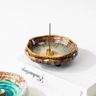 Handmade Japanese wabi-sabi style ceramic incense holder with warm brown crackle glaze and a brass incense insert on a white background.
