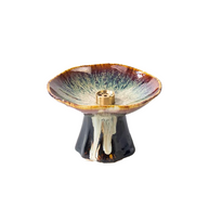 Japanese minimalist ceramic incense holder with a pedestal base, shallow glazed dish, and brass incense insert, featuring earthy brown, cream, and black tones on a clean white background.