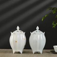 Two lotus shaped electric ceramic incense burners displayed together showing the green and white color options on a tabletop