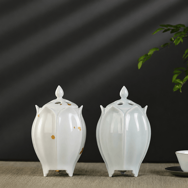Two lotus shaped electric ceramic incense burners displayed together showing the green and white color options on a tabletop