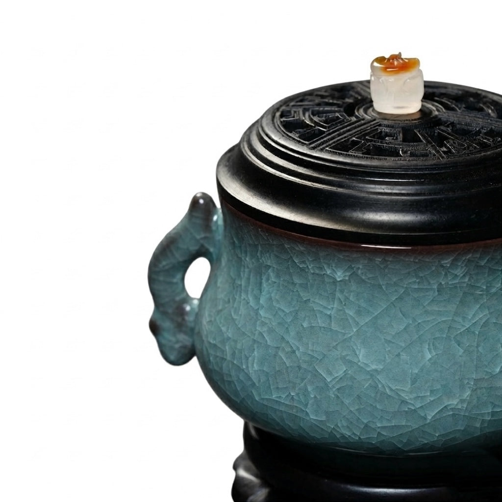 Close-up of a luxury electric incense burner with a Ge kiln ice-crackle ceramic body, black lid, and decorative side handle