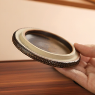 Close-up of the round ceramic base for the Peaceful Little Monk Incense Burner, showing its textured rim and handheld size.