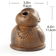 Peaceful Little Monk Incense Burner shown with size markings of 3.8 in / 9.6 cm width and 4.6 in / 11.6 cm height, featuring a brown ceramic monk design with a smoke outlet and prayer bead details.