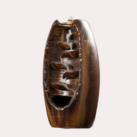 Premium high-fired ceramic backflow incense holder in a rustic brown glaze with visible cascading smoke channels and an incense cone on top against a white background