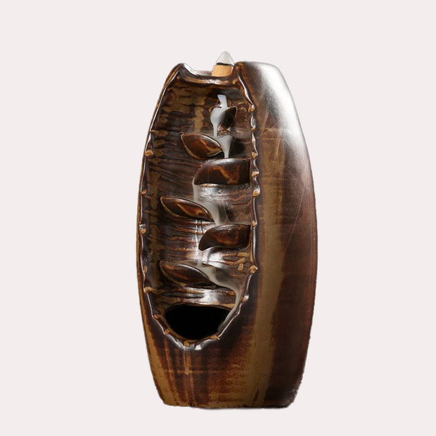 Premium high-fired ceramic backflow incense holder in a rustic brown glaze with visible cascading smoke channels and an incense cone on top against a white background