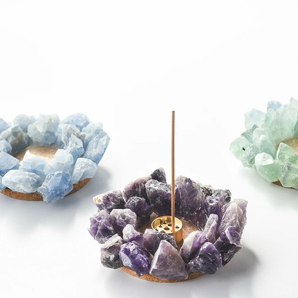 Raw purple amethyst incense holder with stick shown with blue calcite and green fluorite crystal holders in background