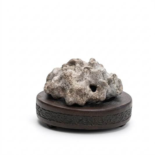 Rock-shaped handmade purple clay incense burner with a porous natural-stone look, displayed on a dark round carved base against a white background.