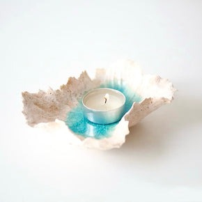 Sea Blossom handmade ceramic incense and candle holder with an organic sculpted rim and ocean blue glaze center, displayed with a tealight candle on a clean white background