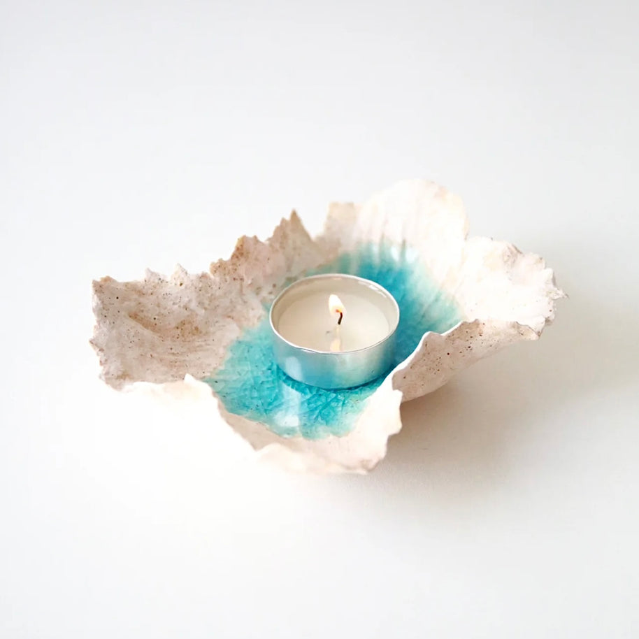 Sea Blossom handmade ceramic incense and candle holder with a blue lagoon glaze center, shown holding a tealight candle on a clean white background