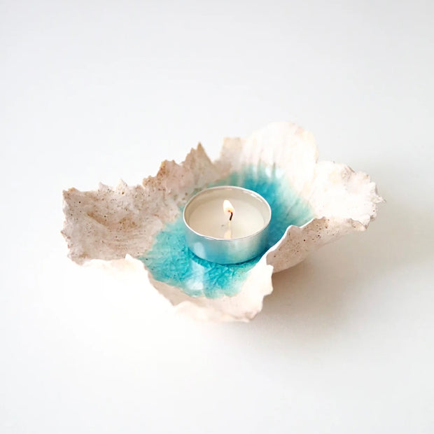 Sea Blossom handmade ceramic incense and candle holder with a blue lagoon glaze center, shown holding a tealight candle on a clean white background