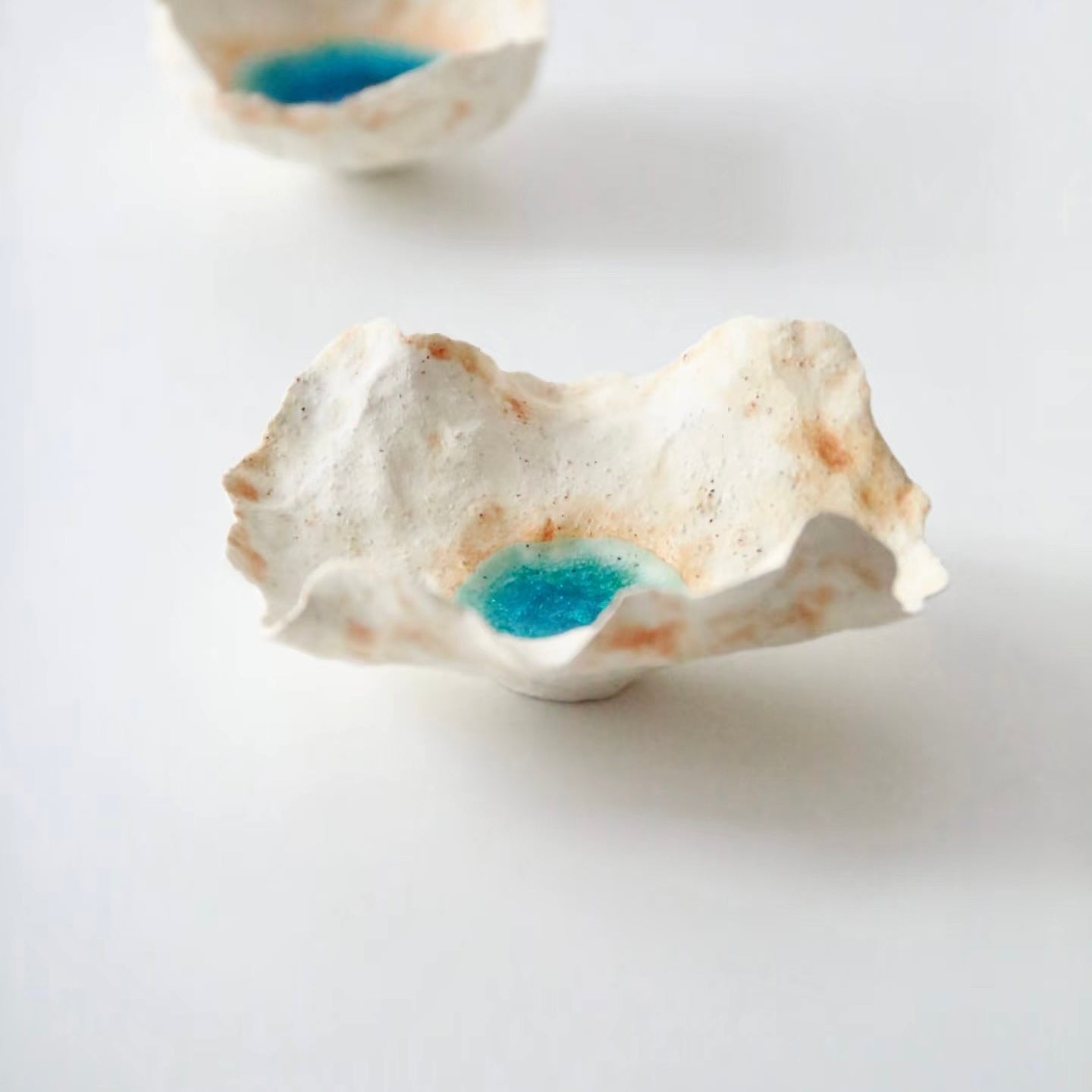 Side profile of the Sea Blossom handmade ceramic incense holder featuring organic sculpted edges, a coastal-inspired white clay finish, and a vivid blue glaze center on a clean white background