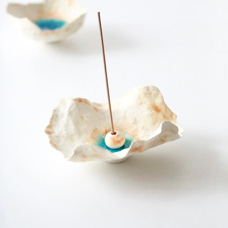 Sea Blossom handmade ceramic incense holder with organic sculpted edges, blue glaze center, and white ceramic bead, displayed with an incense stick on a clean white background